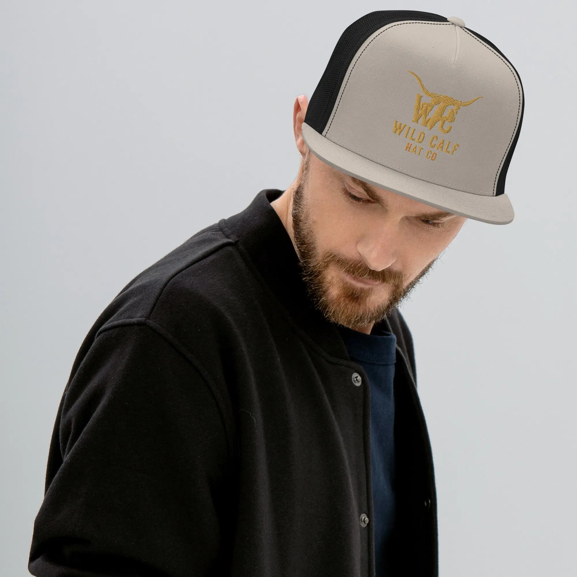 Western-inspired silver and black trucker cap with embroidered logo, worn professionally
