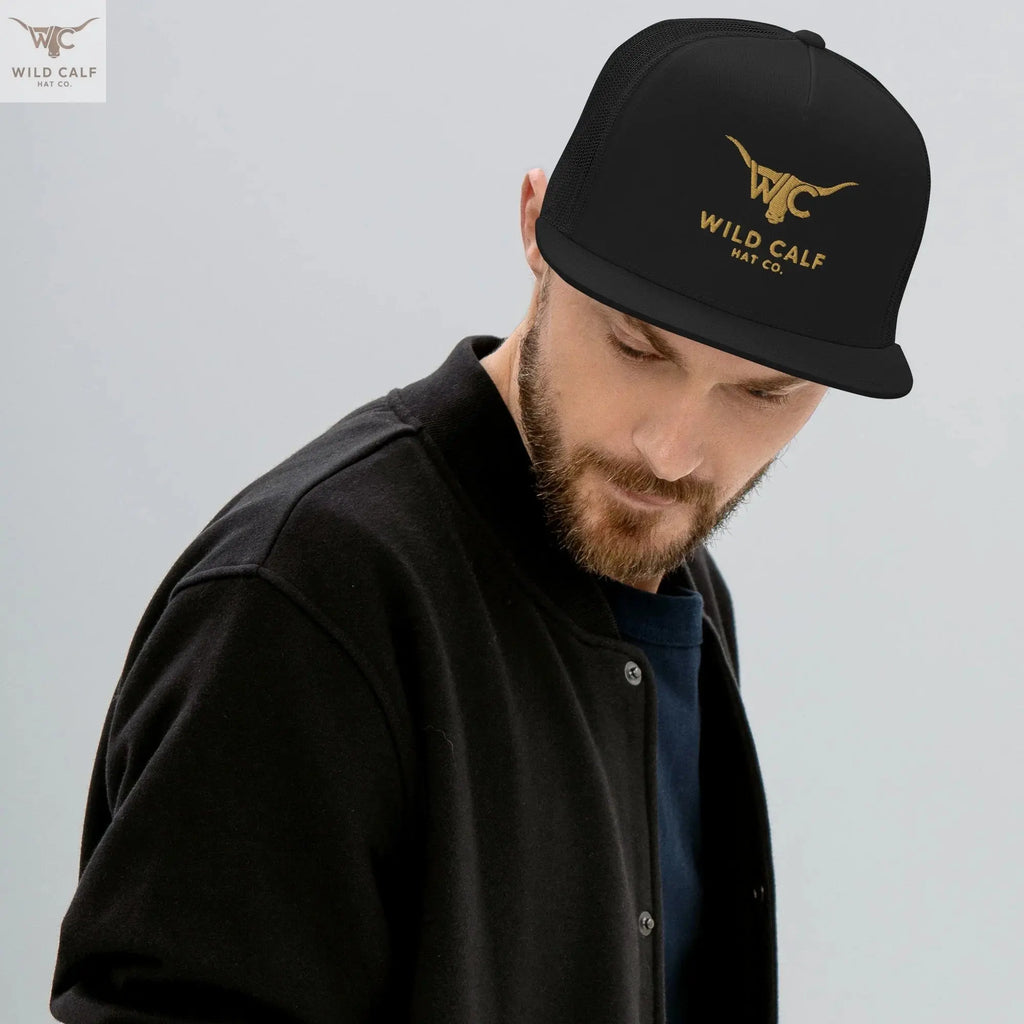 Man wearing black western trucker cap with gold logo and longhorn graphic, professional style
