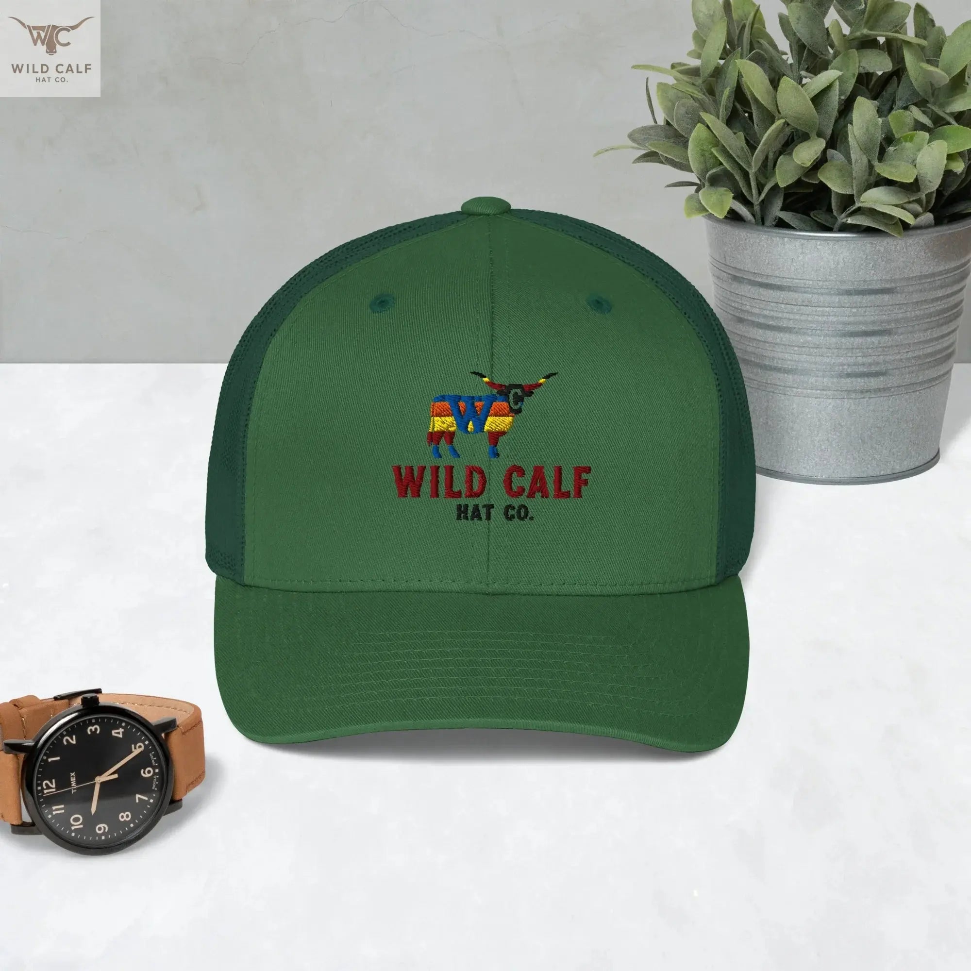 Evergreen retro trucker hat with embroidered western longhorn design, styled on a table