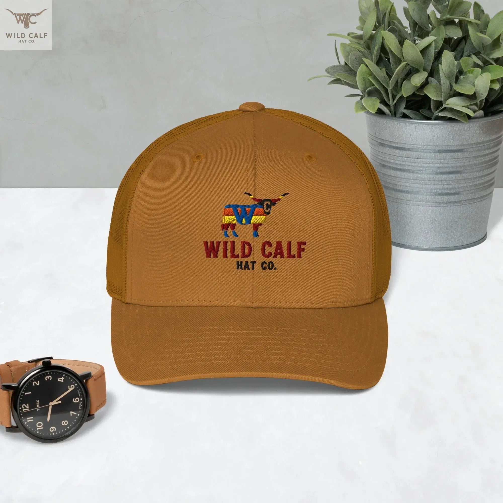 caramel retro trucker hat with embroidered western bull logo, styled on a modern desk