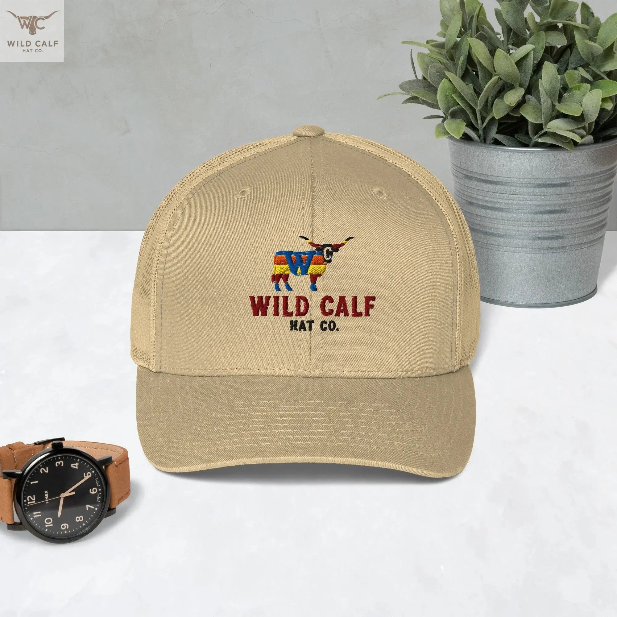 Khaki retro trucker hat with colorful longhorn logo, western professional style, on a table.